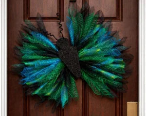 Peacock feather wreath with black mesh accents, perfect for baby shower decor or memorial keepsakes