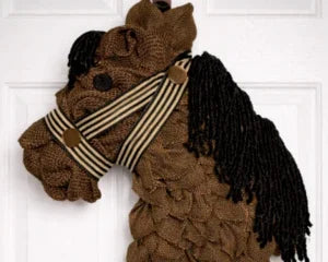 Handmade horse wreath with striped ribbon, crafted from cozy fabric for baby shower gifts or keepsakes.